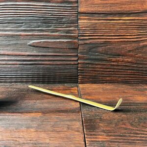 Japanischer Matcha-Löffel aus Bambus (Chashaku) auf dunklem Holztisch. Produkt aus dem iūgen Shop.